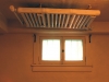 Steam radiator mounted over basement window